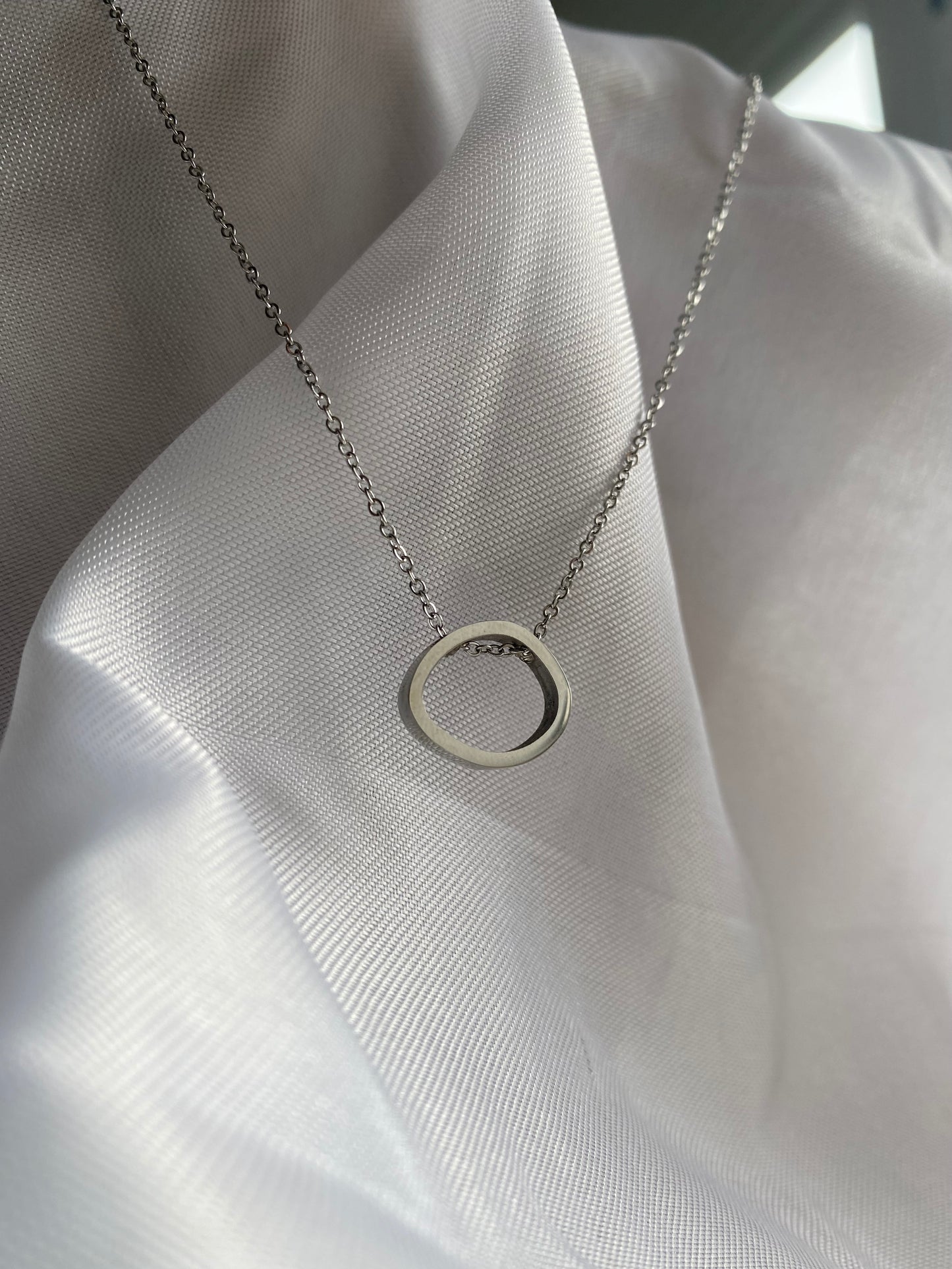 Colar Brya em aço inoxidável e hipoalergénico, com argola geométrica prateada.