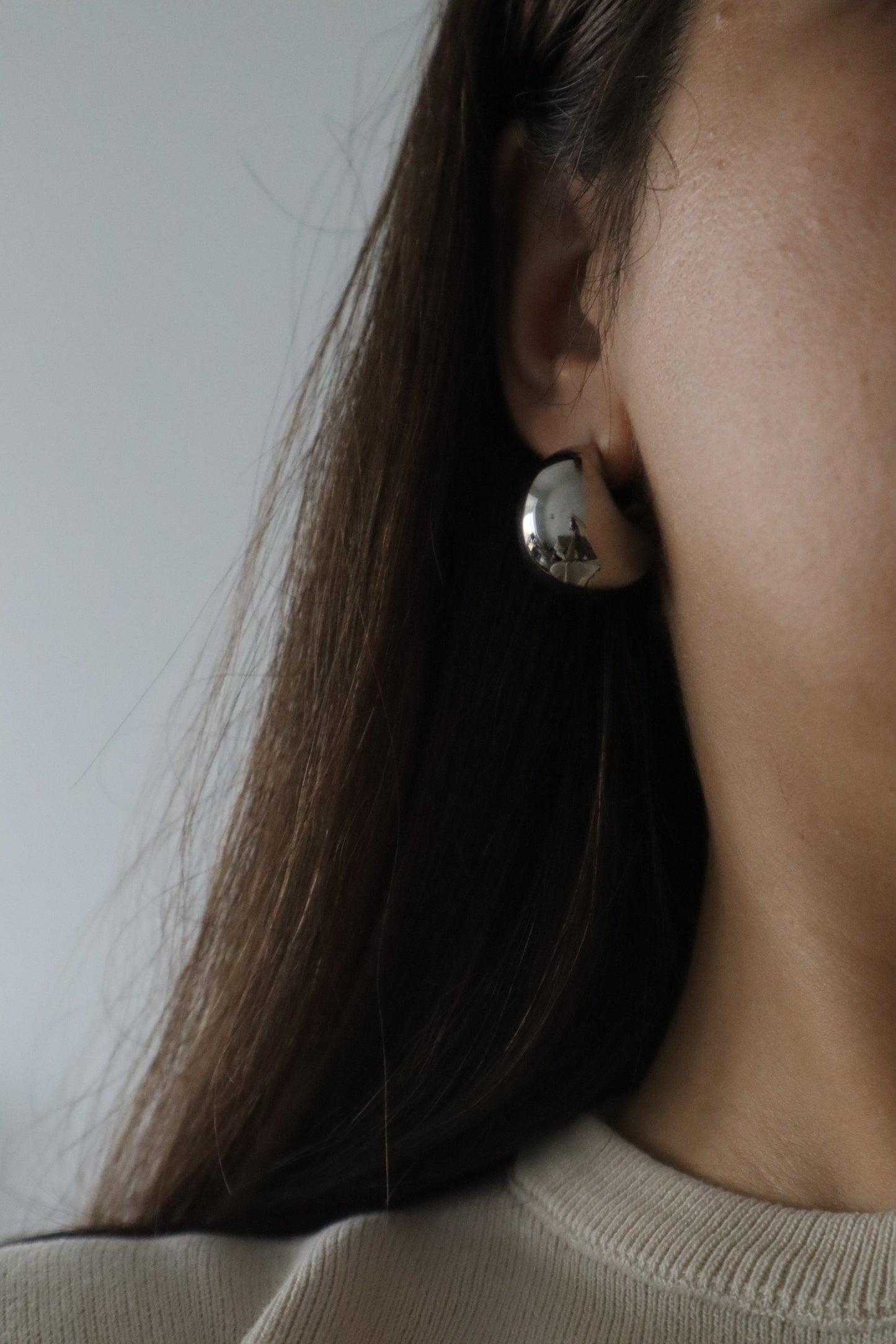 Brincos redondos, em balão, de aço inoxidável prateado.