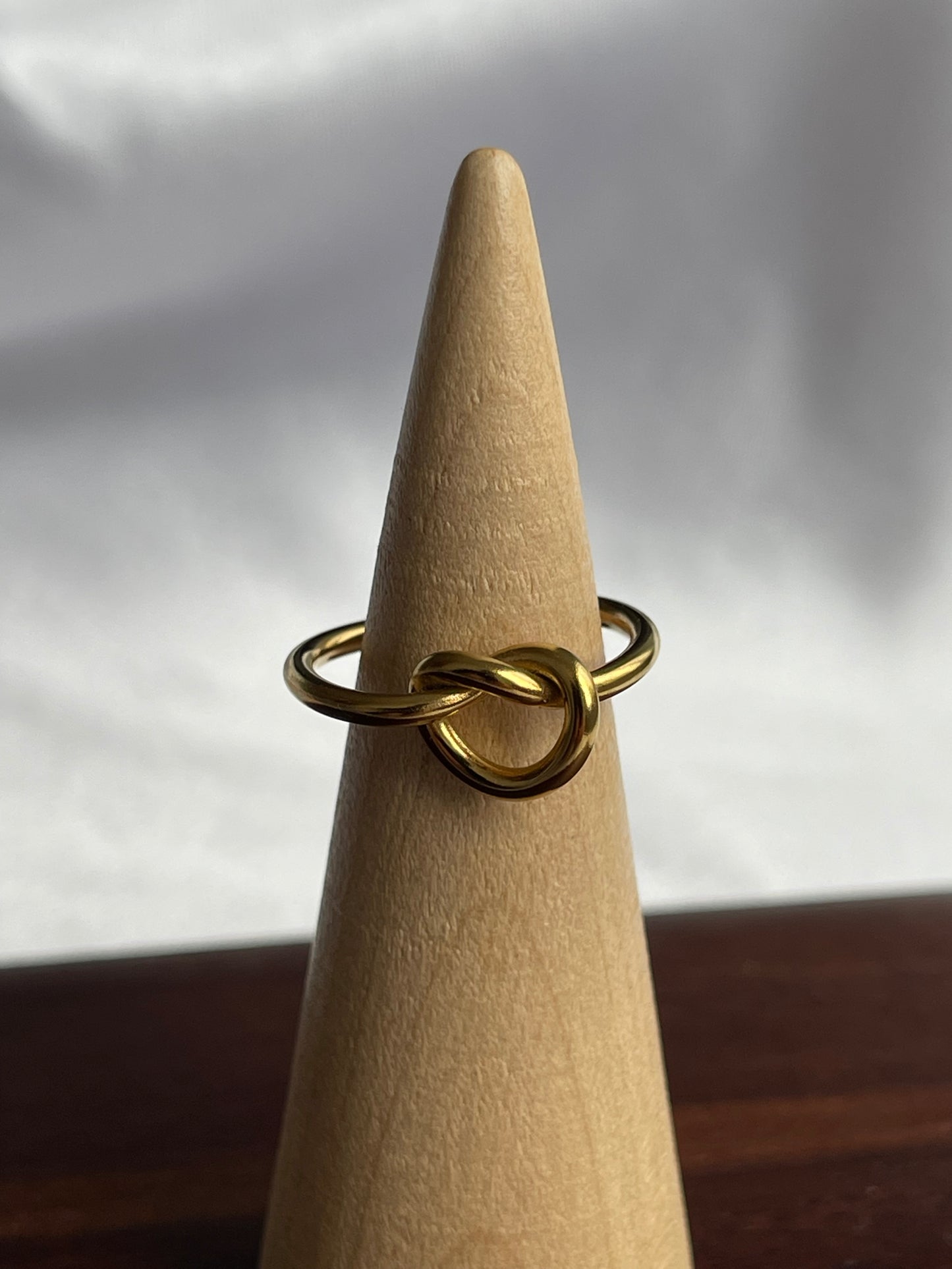 Anel Bay em aço inoxidável com design em nó minimalista.