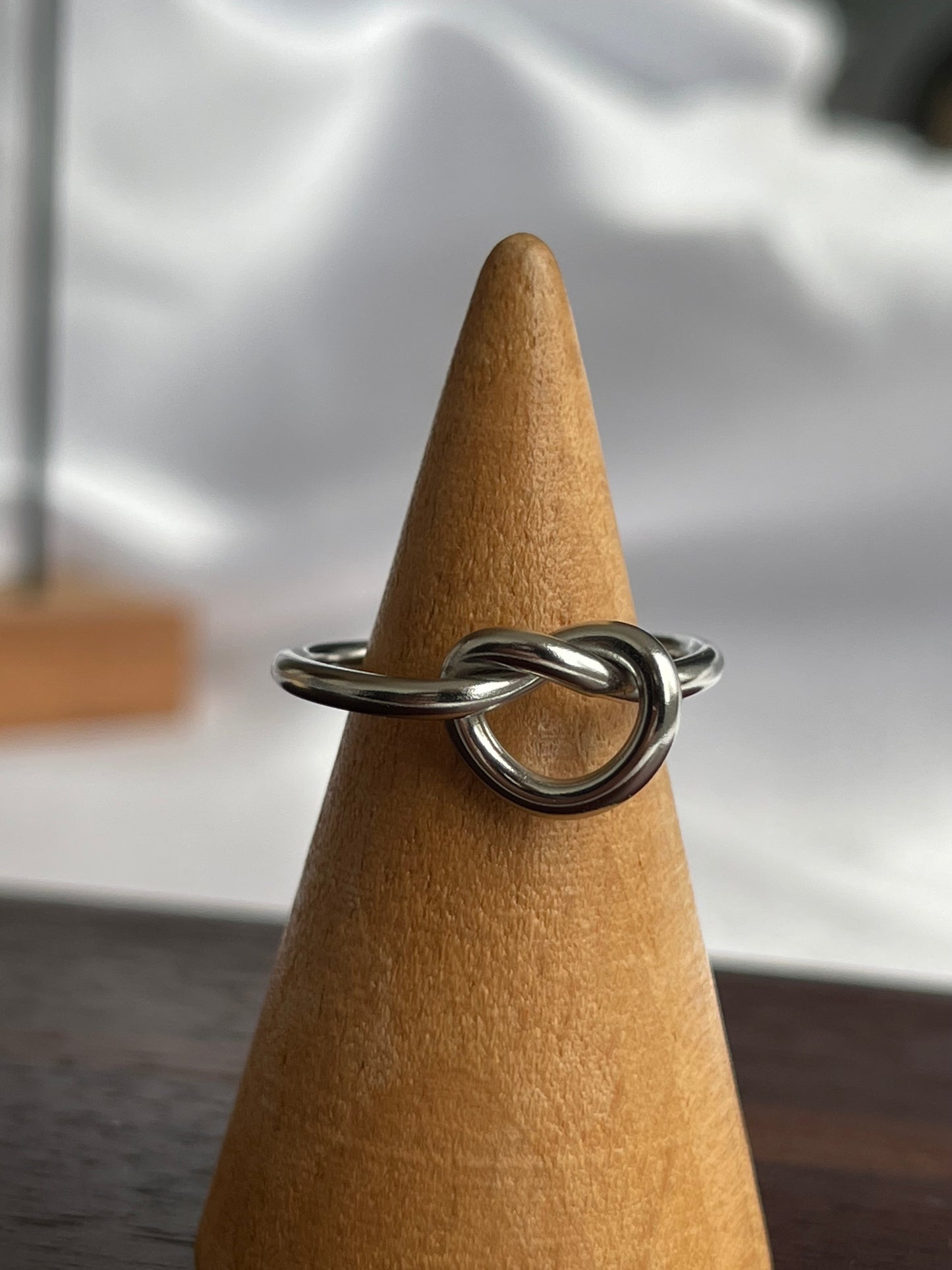 Anel Bay em aço inoxidável com design em nó minimalista.