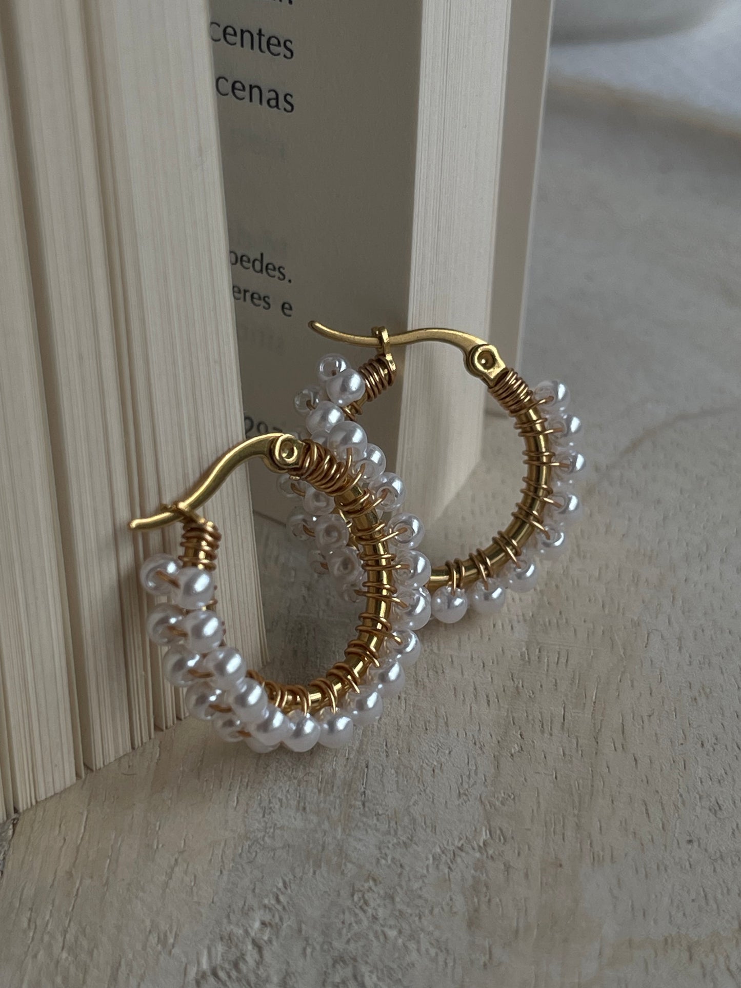 Brincos Camomila dourados com pérolas brancas em aço inoxidável.