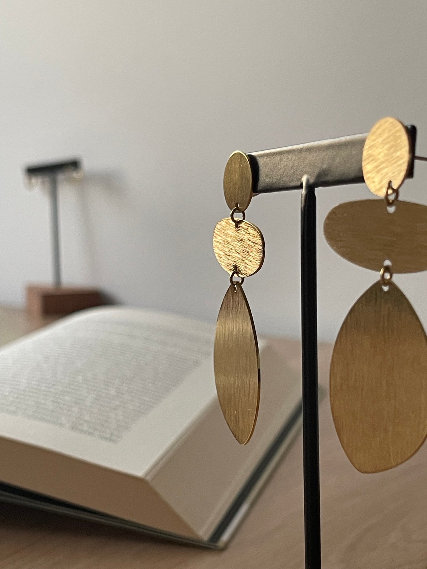 Brincos Cato dourados com acabamento escovado em aço inoxidável.