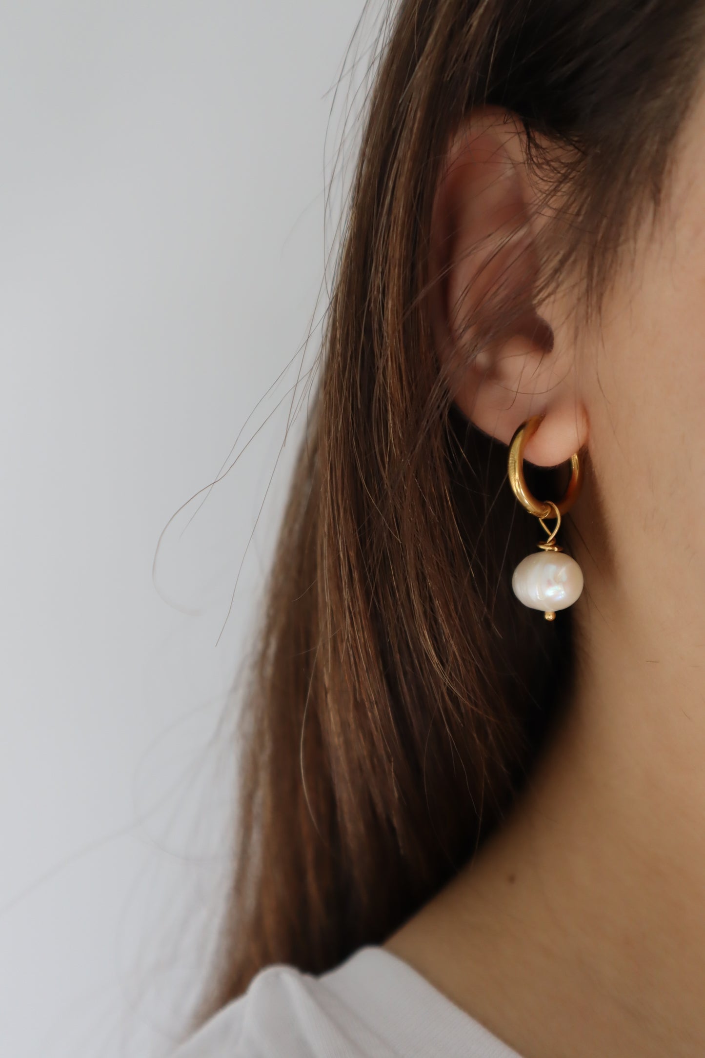 Brincos Hortênsia em aço inoxidável dourado com pendente de pedra de água doce.