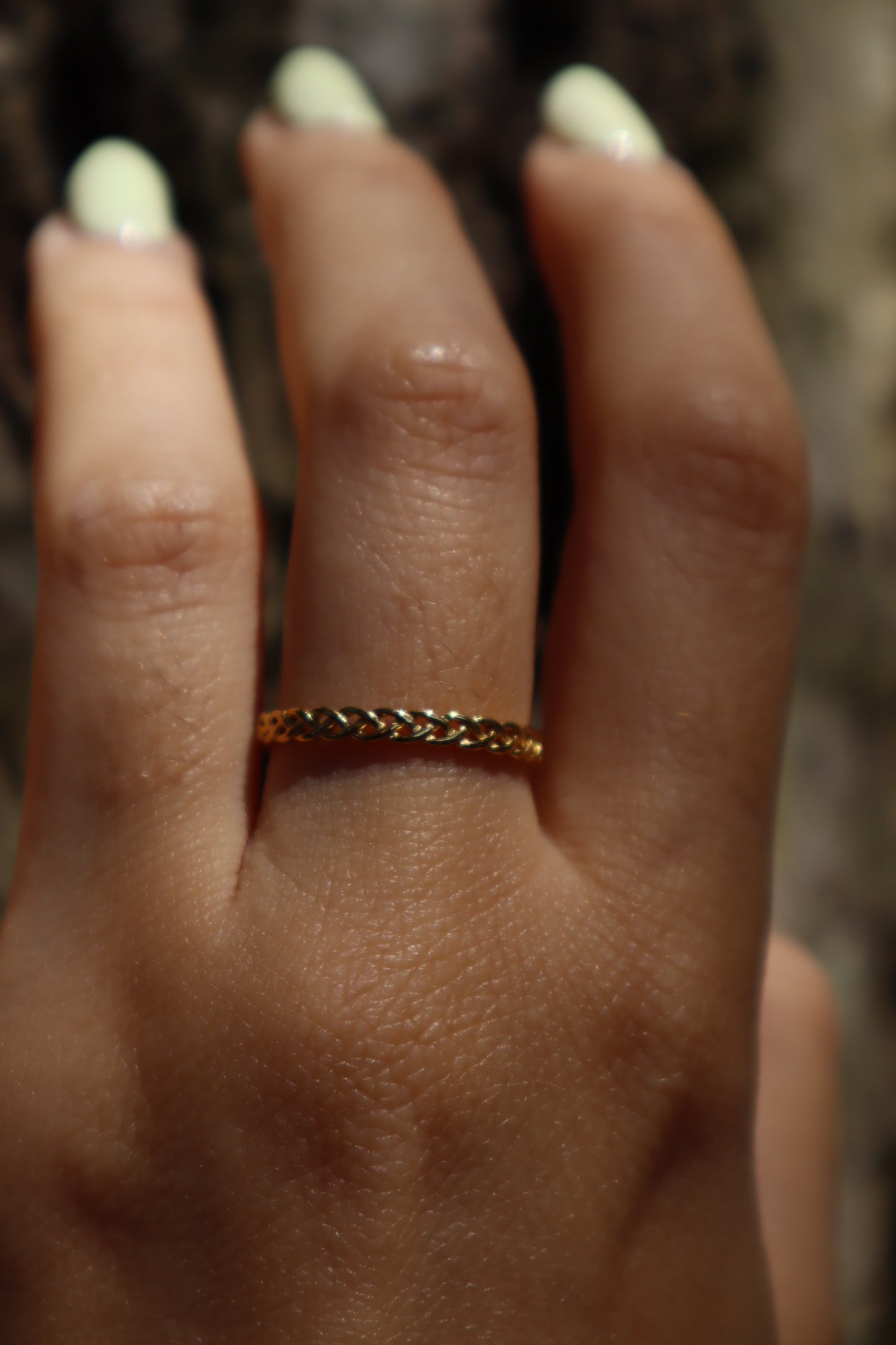 Anel Liatris em aço inoxidável dourado com design entrelaçado.