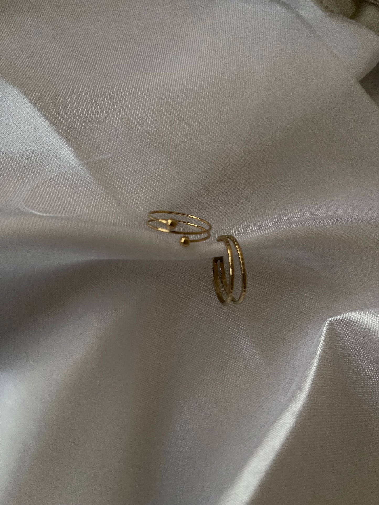 Anel Linho e Anel Dália, ambos em aço inoxidável dourado, com tamanhos ajustáveis.