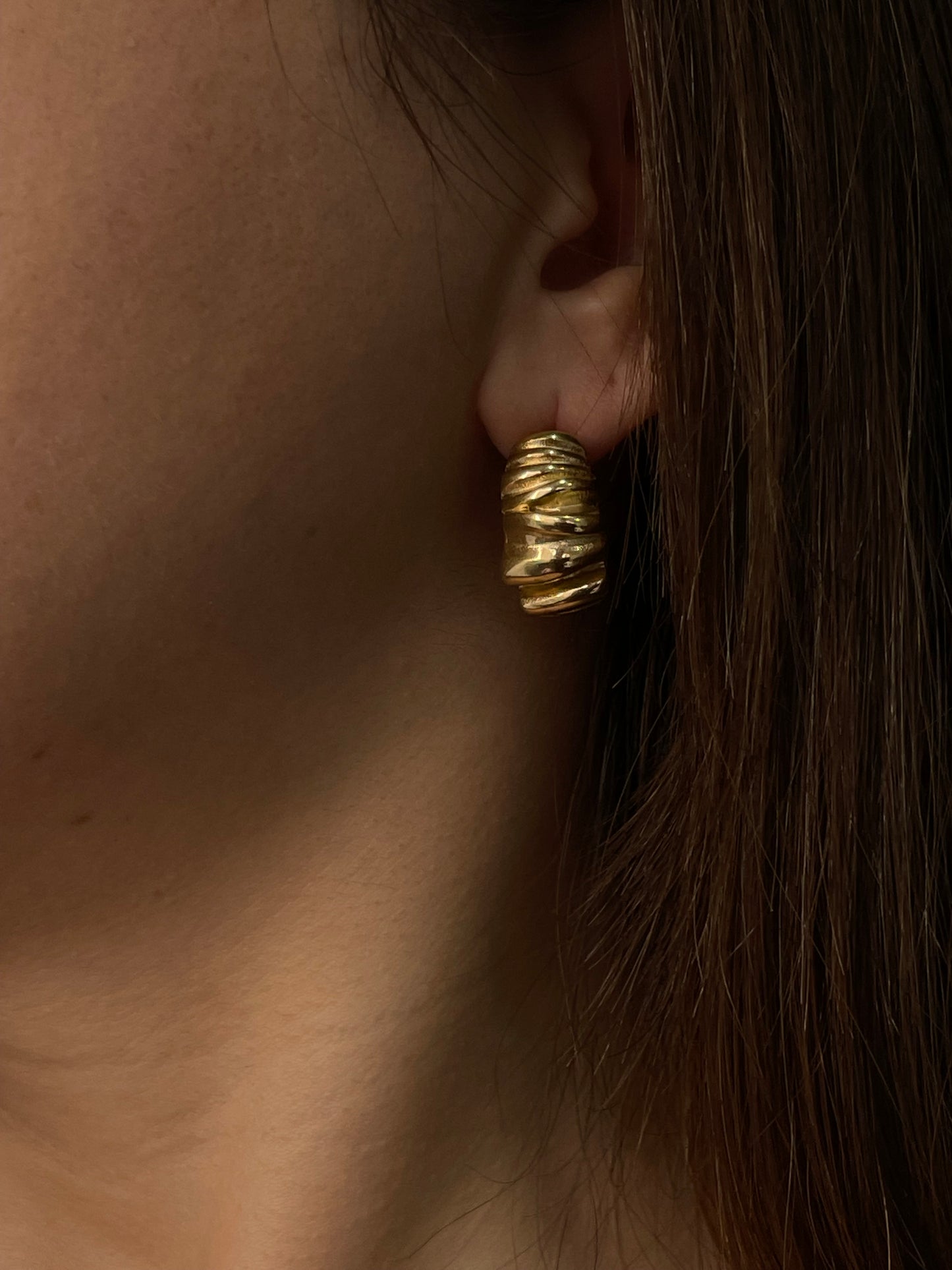 Brincos Melissa em aço inoxidável dourado com design ondulado e robusto.