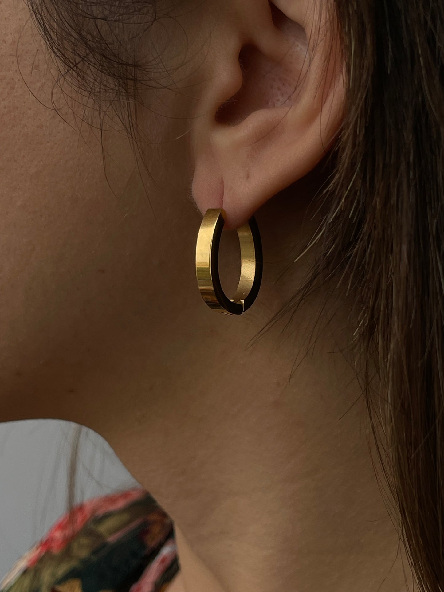 Brincos Olive, argolas de aço inoxidável dourado com design oval minimalista.