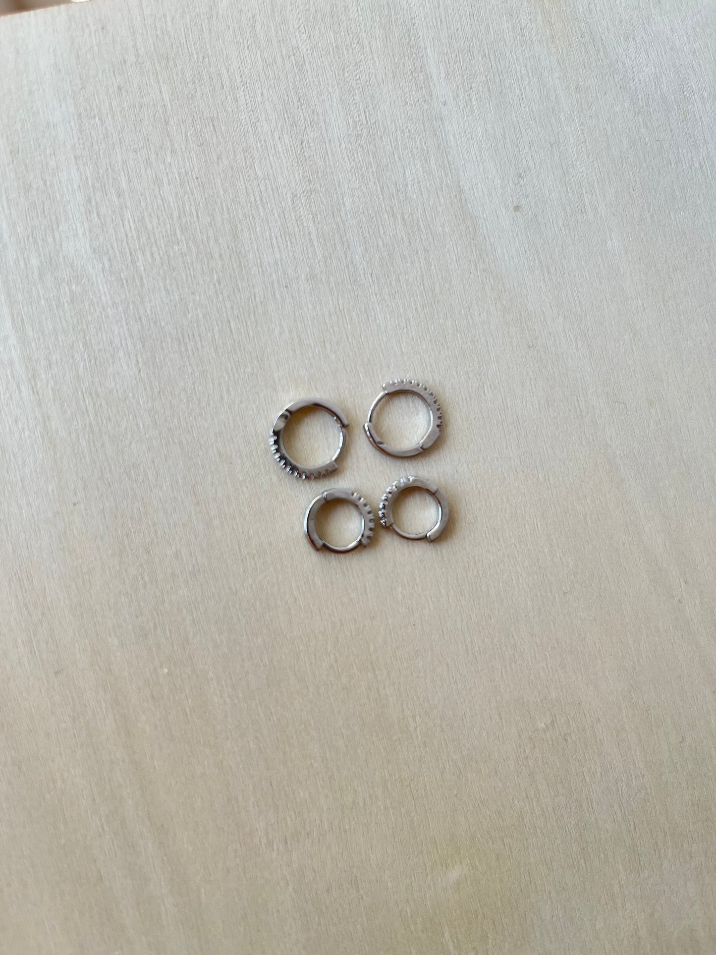 Brincos Silene em aço inoxidável prateado, perfeitos para o segundo furo, disponíveis nos tamanhos M e S.