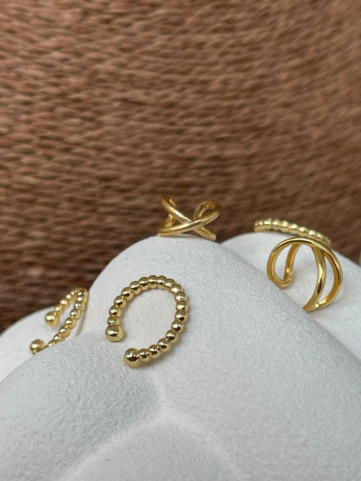 Earcuff Jasmim em aço inoxidável dourado com design de esferas, sem necessidade de furo.
