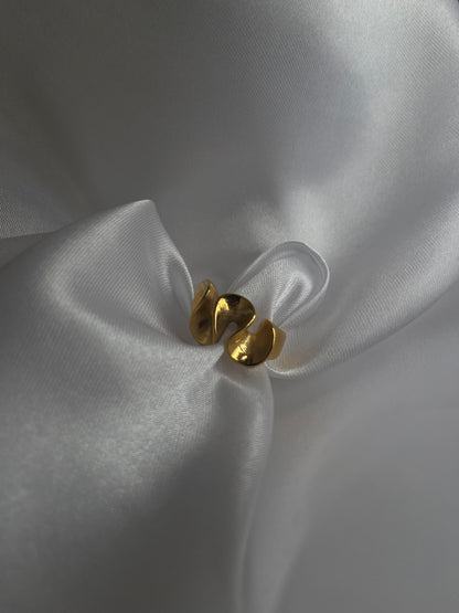 Anel Loureiro em aço inoxidável dourado com design curvo.